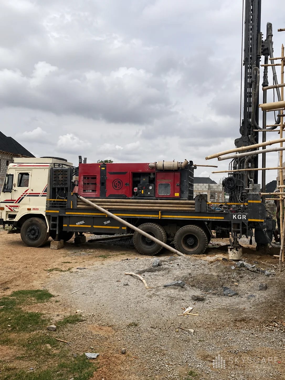 Truck-mounted borehole drilling rig installing a water supply borehole on a construction site